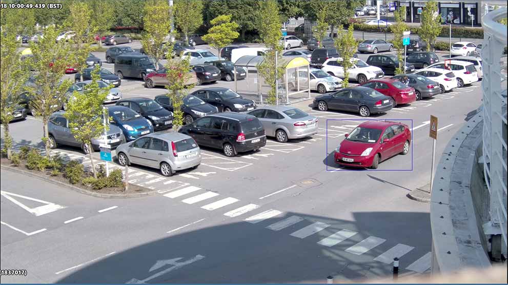 view of shopping centre carpark with red car highlighted as seen from avigilon cctv camera